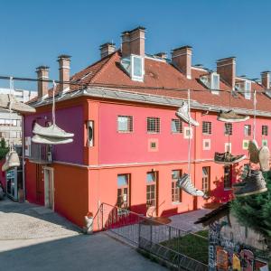 a colorful building with shoes hanging from wires at Hostel Celica in Ljubljana