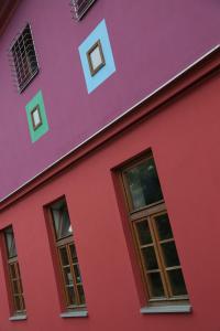 a pink building with a red door and red walls at Hostel Celica Art in Ljubljana