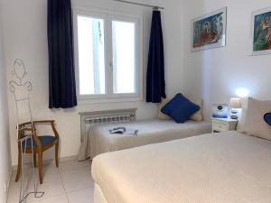- une chambre avec deux lits, une fenêtre et une chaise dans l'établissement House Sarzano by Holiday World, à Gênes