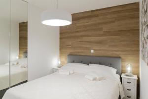 1 dormitorio con 1 cama blanca grande y 2 toallas en Apartman Toni, en Split