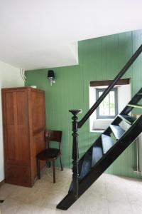 een kamer met een trap, een stoel en een raam bij Le Repere du Cerf in Herbeumont