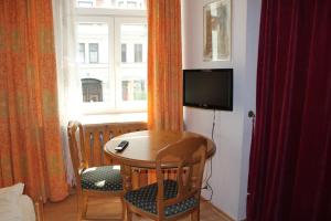 a small table and chairs in a room with a window at Hotel Atlanta in Munich