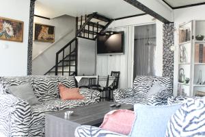 un soggiorno con divani zebrati e TV di House Alexandros a Limenas