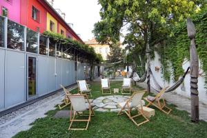 a group of chairs sitting on the grass near a building at Hostel Celica in Ljubljana
