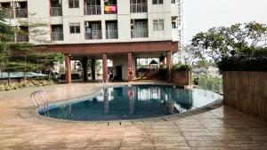 a swimming pool in front of a building at Cozy Studio Serpong Greenview Apartment By Travelio in Ciater-hilir