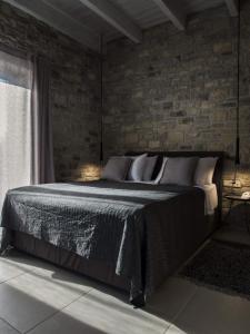 - une chambre avec un lit et un mur en briques dans l'établissement Casa Della Vita Gouves Cretan Luxury Villa, à Gournes