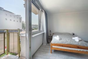 um quarto com uma cama e uma grande janela em IV apart em Gdynia