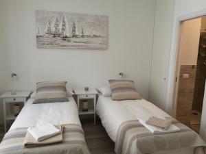 ein Schlafzimmer mit 2 Betten und einem Bild an der Wand in der Unterkunft Julia apartment in Triest