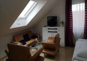 ein Wohnzimmer mit Sofas, einem TV und einem Fenster in der Unterkunft Apartment Hotel Alena in Filderstadt