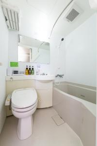 四日市的住宿－四日市站前三交酒店，白色的浴室设有卫生间和浴缸。