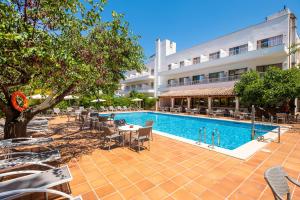 a hotel with a pool and tables and chairs at Hotel Gaya in Paguera
