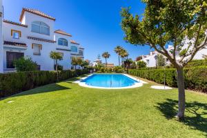 un patio con piscina frente a una casa en Apartaluz Marbella Costabella ,Satélite, Wifi, Pk, en Marbella