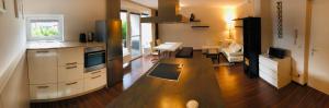 25h GARDEN Apartment PLUS private Beach في نيوسيدل آم سي: مطبخ مع طاولة خشبية في الغرفة