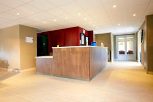 an empty lobby with a reception desk in a building at Campanile Lyon Sud Feyzin in Feyzin