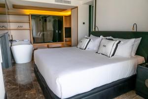 
a hotel room with two beds and a mirror at BLESS Hotel Ibiza - The Leading Hotels of The World in Es Cana
