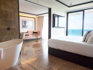 a hotel room with a tub and a balcony at BLESS Hotel Ibiza - The Leading Hotels of The World in Es Cana