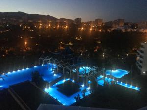 a night view of a amusement park with blue lights at Benalbeach JR Suite in Málaga