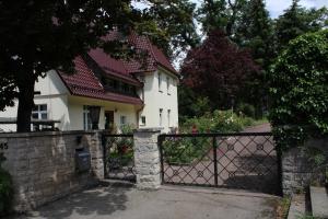 Uma casa branca com um portão à frente. em Ferienwohnung in herrlicher Lage em Bad Urach