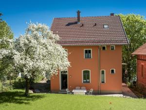 ein Haus mit einem blühenden Baum im Hof in der Unterkunft Holiday home with terrace in Eisenach