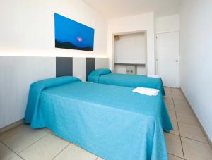 a hospital room with two beds with blue sheets at Apartamentos Tramuntana in San Antonio
