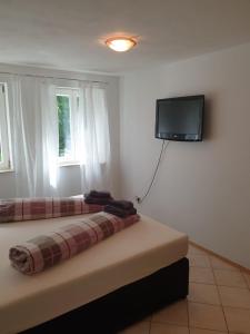a bedroom with a bed and a tv on the wall at FeWo Am Ohrensbächle in Glottertal