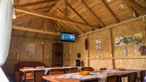 a room with wooden tables and a tv on the wall at Casa din Gradina in Eforie Sud