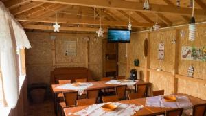 a dining room with wooden tables and a tv at Casa din Gradina in Eforie Sud