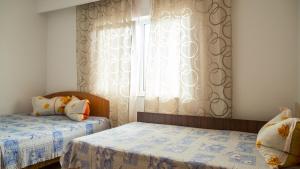 a bedroom with two beds and a window at Casa din Gradina in Eforie Sud