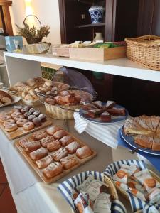 una mesa llena de diferentes tipos de pasteles y tartas en Hotel Mare en Portoferraio