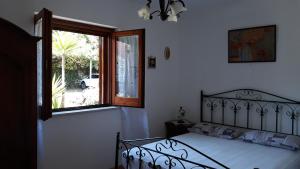 een slaapkamer met een bed en een groot raam bij Country Bellavista in Marina di Camerota