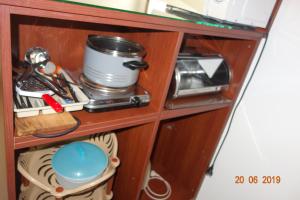 a wooden cabinet with dishes and utensils on it at КЪЩА"Перла" in Ravda