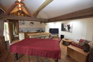 a living room with a red bed and a kitchen at Oak tree stables cottage in Birmingham