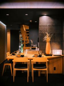 a dining room with two tables and a vase on the wall at SAMURAI HOUSE Ⅱ in Nagoya