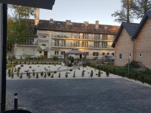 a building with a courtyard with plants in front of it at Apartamenty u Tatiany in Międzywodzie
