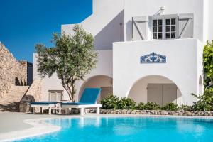 a villa with a swimming pool in front of a house at LavaRock Santorini in Perissa