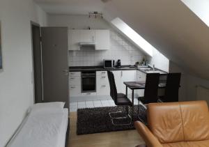 eine Küche mit einem Tisch und Stühlen im Zimmer in der Unterkunft Apartment Hotel Alena in Filderstadt