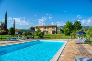 una villa con piscina di fronte a una casa di Agriturismo Le Terre del Casale ad Assisi