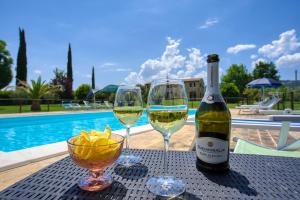 una bottiglia di vino e due bicchieri su un tavolo di Agriturismo Le Terre del Casale ad Assisi