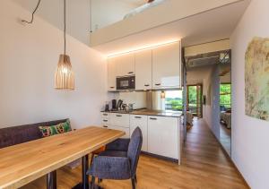 eine Küche und ein Esszimmer mit einem Holztisch in der Unterkunft Ferienwohnungen Boardinghouse Bodensee in Gaienhofen