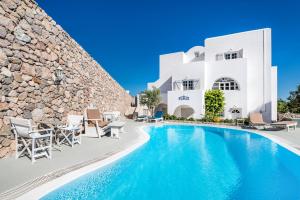 a villa with a swimming pool in front of a building at LavaRock Santorini in Perissa