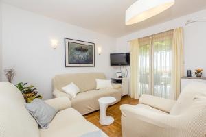 a living room with two couches and a tv at Apartments Marica in Skrbčići