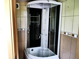 a bathroom with a shower with a glass door at Pensiunea Roua Florilor in Anina