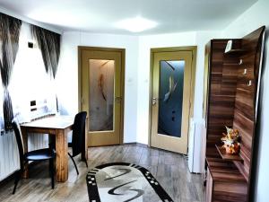 a home office with two doors and a desk and a rug at Pensiunea Roua Florilor in Anina