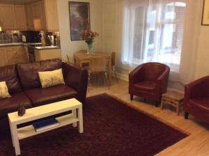 een woonkamer met een bank, 2 stoelen en een tafel bij Stansted spacious 2-bed apartment, easy access to Stansted Airport & London in Stansted Mountfitchet