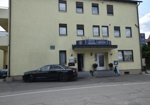 ein schwarzes Auto, das vor einem Gebäude parkt in der Unterkunft Apartment Hotel Alena in Filderstadt