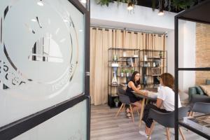 two women sitting at a table in a coffee shop at SingularStays Parque Central in Valencia