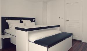 a bedroom with a bed with a black and white headboard at Le Grand Hotel de la Plage in Biscarrosse-Plage