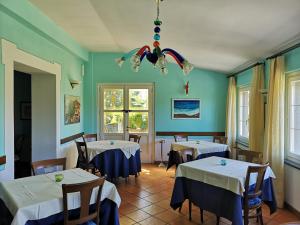 a dining room with two tables and a chandelier at Locanda Miranda in Tellaro