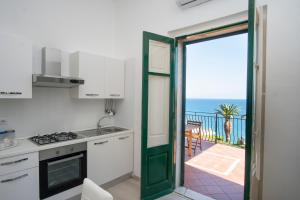 een keuken met een deur naar een balkon met uitzicht op de oceaan bij orizzonti di mare in Marina di Camerota