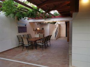 an outdoor patio with a wooden table and chairs at VILLA V&D in Milna